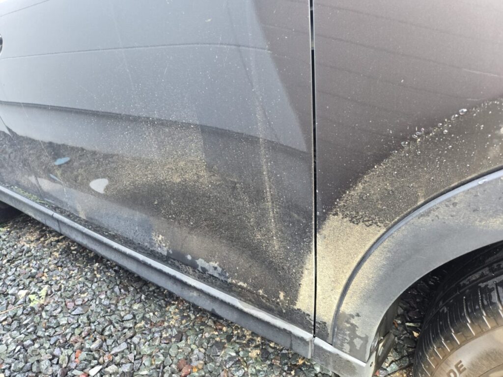 洗車機に入れる前に確認したい、ドア下部やフェンダーへ泥や砂が付着した車の側面